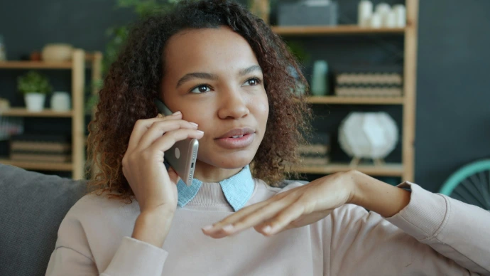 Young woman talking on a smartphone at home